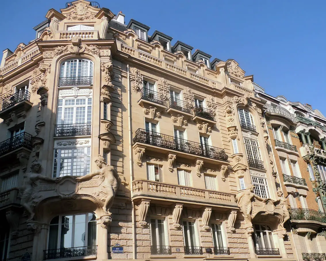Un immeuble de rapport élégant et historique se dresse fièrement sous un ciel bleu parisien, promettant un investissement rentable.