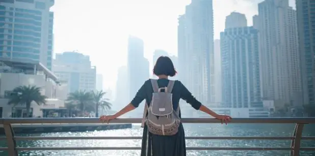 Une personne contemple la skyline de Dubaï, avec les imposants bâtiments d’Armani Beach Residences en toile de fond.