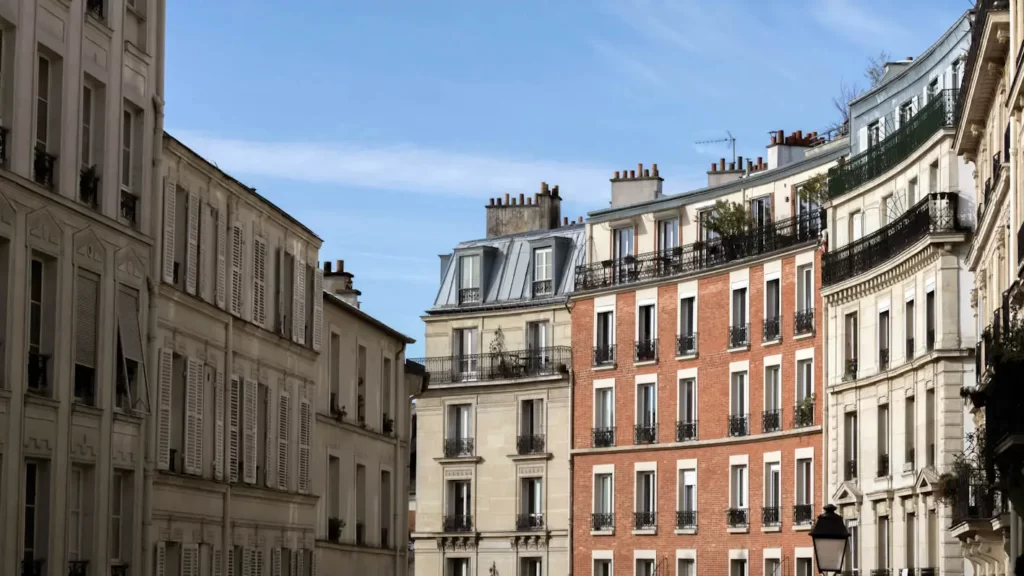 Un immeuble de rapport élégant et historique se dresse fièrement sous un ciel bleu parisien, promettant un investissement rentable.