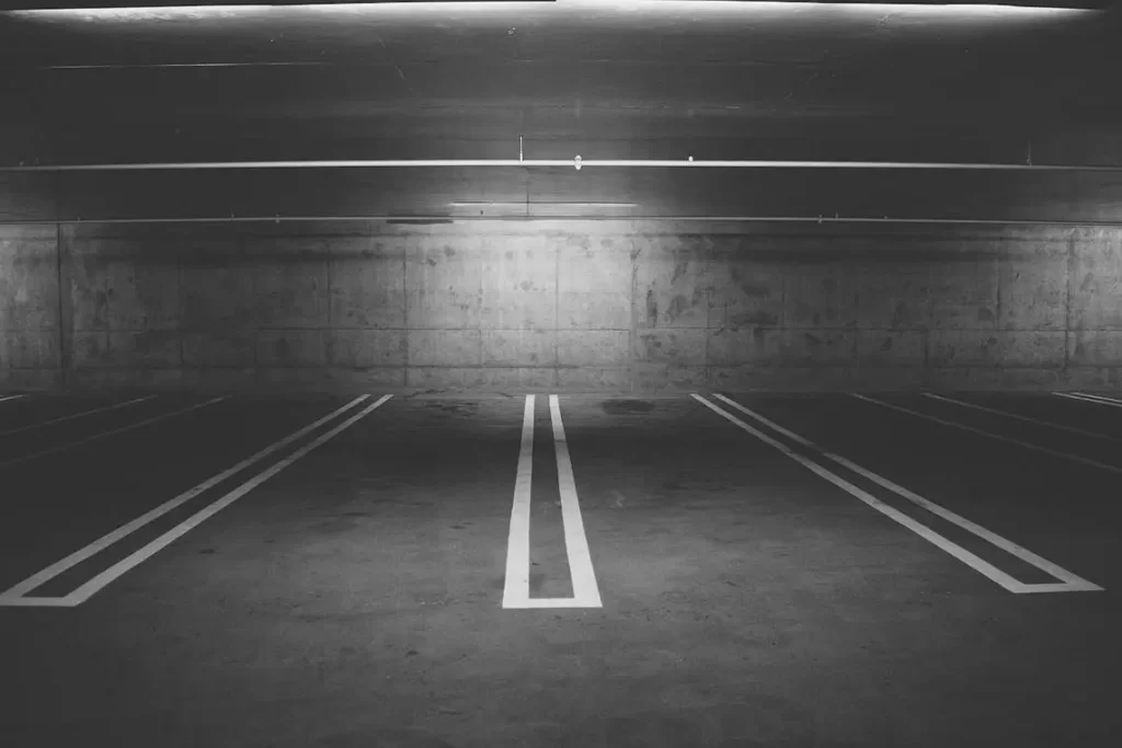 Une place de parking vide et bien éclairée dans un parking souterrain sombre et spacieux.